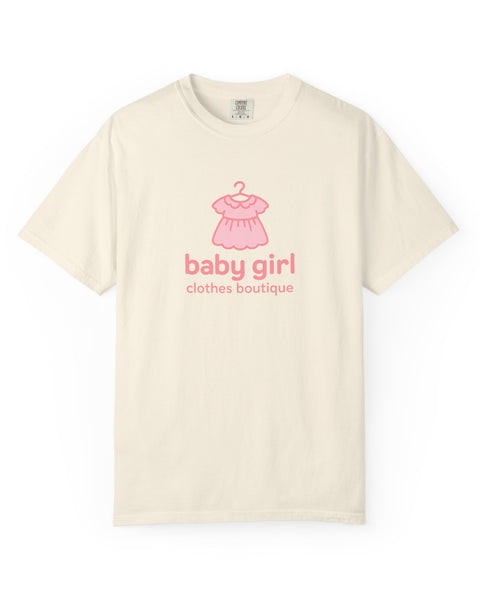 Beige t-shirt with pink baby dress graphic and 'baby girl clothes boutique' text on a white background