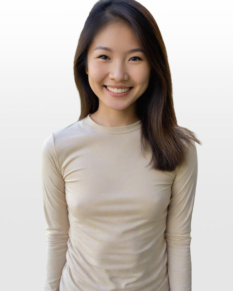 Asian woman wearing a beige long-sleeve shirt against a plain background