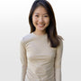 Asian woman wearing a beige long-sleeve shirt against a plain background