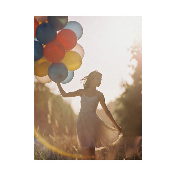whimsical photography poster of a young woman holding colorful balloons in a field with a warm glow