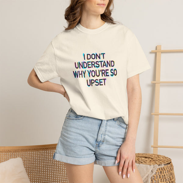 Woman wearing a beige t-shirt with colorful text "I don't understand why you're so upset" and denim shorts in a casual setting.