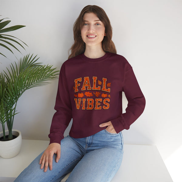 Person wearing a maroon sweatshirt with 'FALL VIBES' text, sitting indoors with a plant in the background.