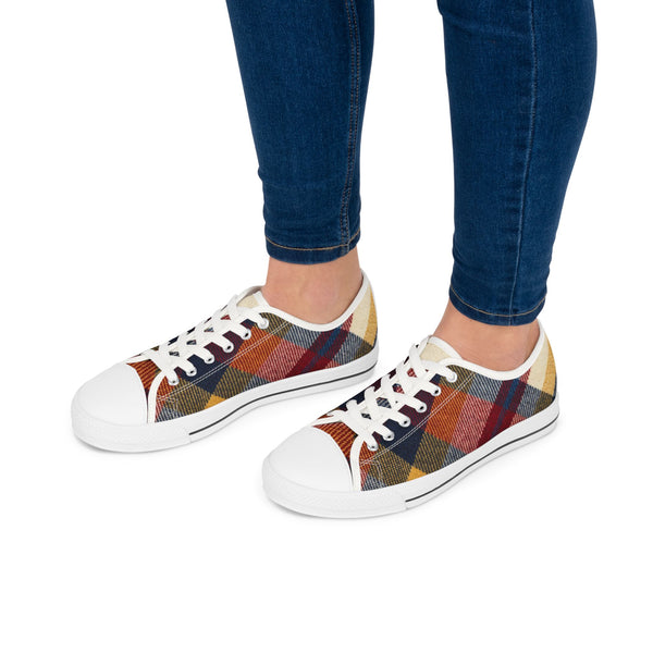 Colorful plaid sneakers worn with blue jeans on a white background