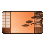 Large desk mat with a surreal landscape with a bonsai tree against an orange sky and Japanese wooden panels.