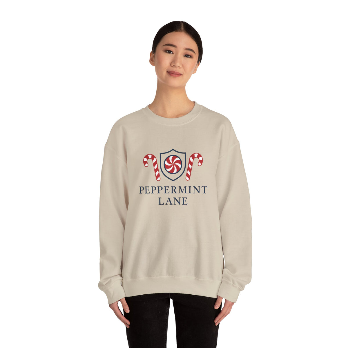 Person wearing a beige sweatshirt with 'Peppermint Lane' design on a white background