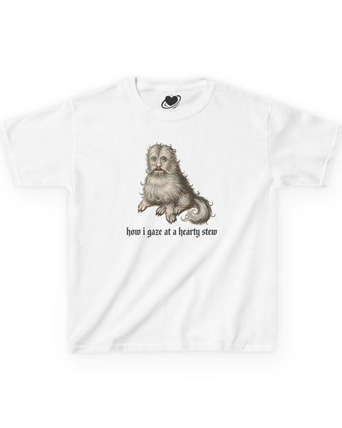 A white baby tee featuring a vintage-style illustration of a medieval dog meme and the text 'how i gaze at a hearty stew' printed on the front.