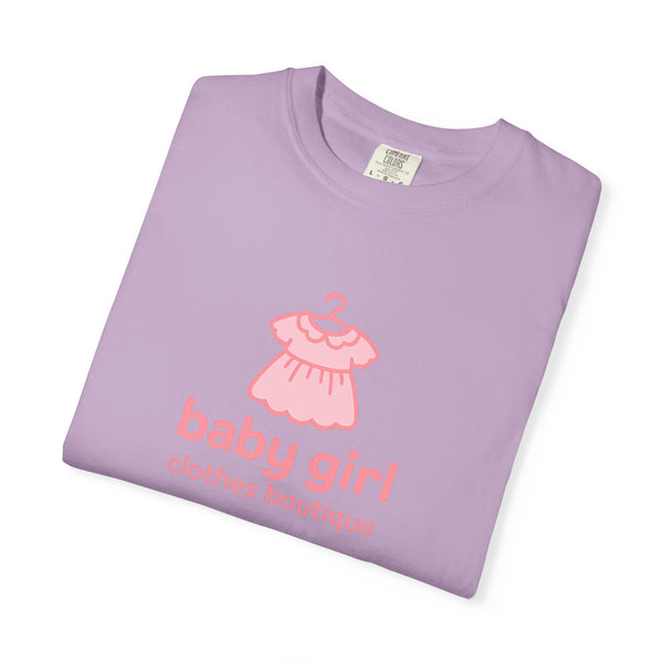 Folded purple t-shirt with pink dress graphic and text on a white background