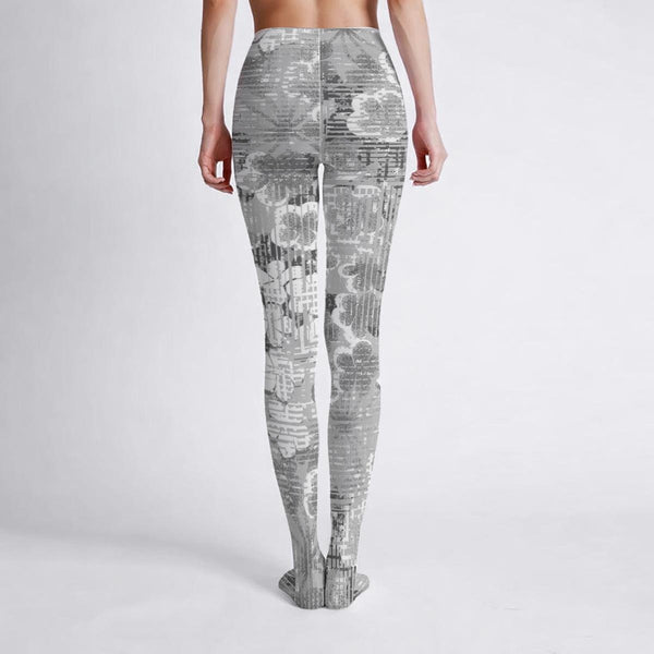 woman wearing gray patterned flower leggings on a white background