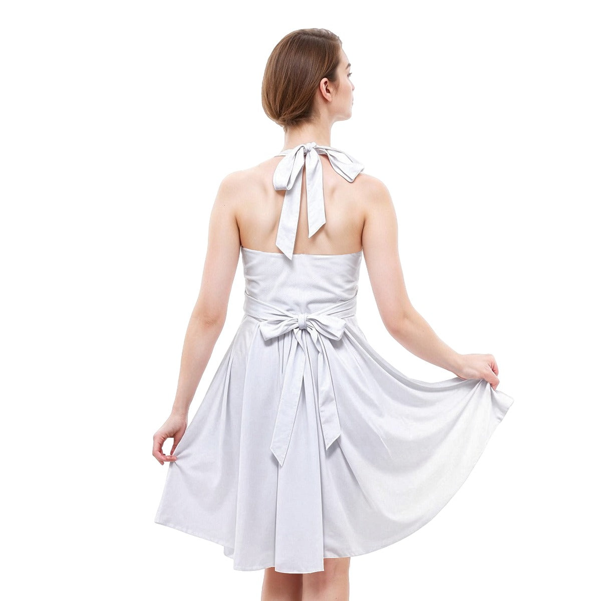 Woman wearing a white halter neck dress with bow details on a white background