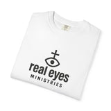 White t-shirt with 'real eyes MINISTRIES' logo on a white background