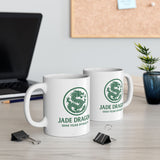 Two white mugs with green dragon logo on a desk with office items.