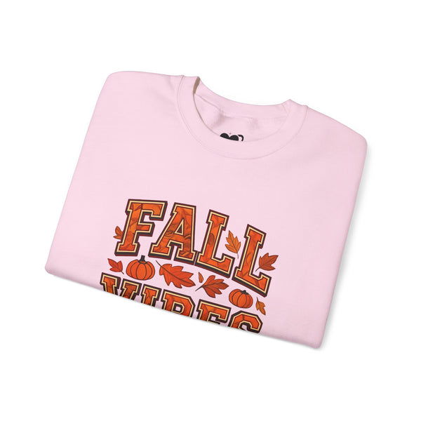 Folded pink sweatshirt with 'Fall Vibes' text and autumn graphics on a white background
