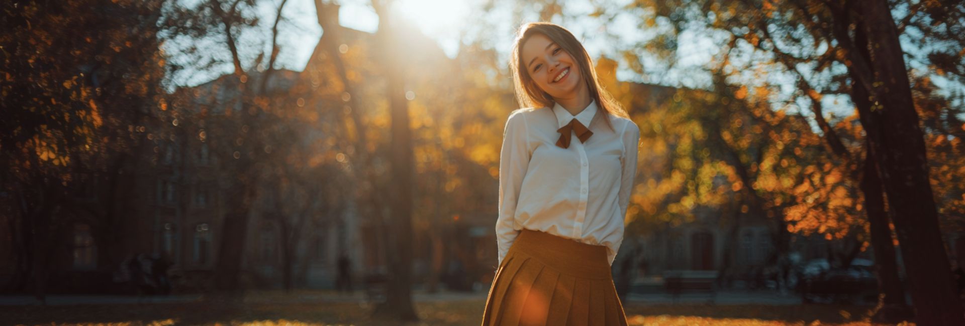  Woman standing in a park with trees and sunlight filtering through
