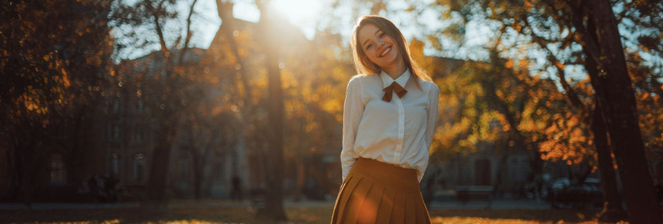  Woman standing in a park with trees and sunlight filtering through