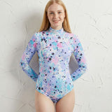 Person wearing a colorful long-sleeve swimsuit against a textured white background