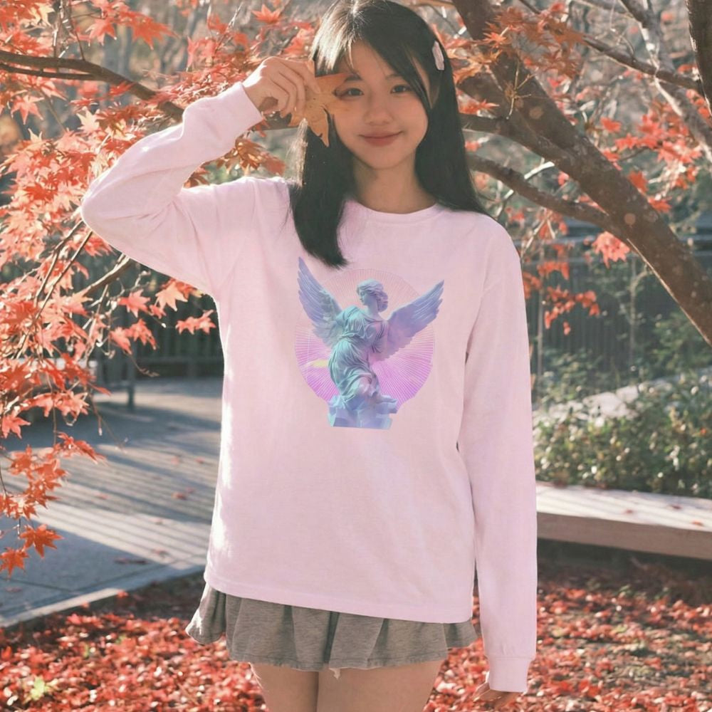 Woman wearing a pink sweatshirt with a  vaporwave graphic design outdoors among autumn leaves.