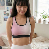 Asian woman wearing a pink wireless bra in a bedroom setting