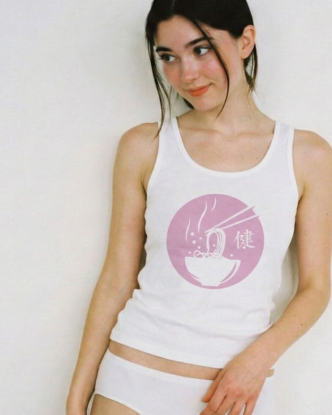 Woman wearing a white tank top with a pink ramen logo on a plain background