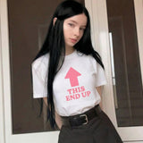 Woman wearing a white t-shirt with a pink graphic and text that reads 