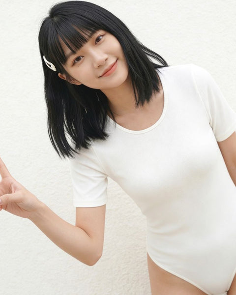 Asian Woman wearing a white t-shirt bodysuit against a plain background