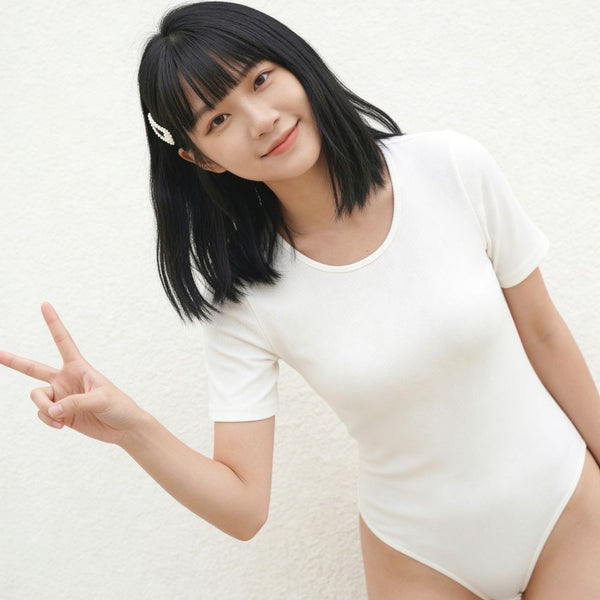 Asian Woman wearing a white t-shirt bodysuit against a plain background